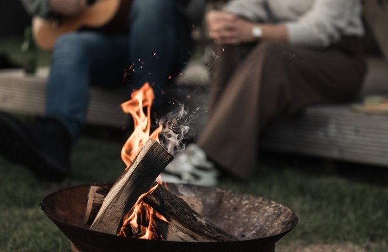 Camping hazenoord kamperen en gitaar spelen bij vuurschaal